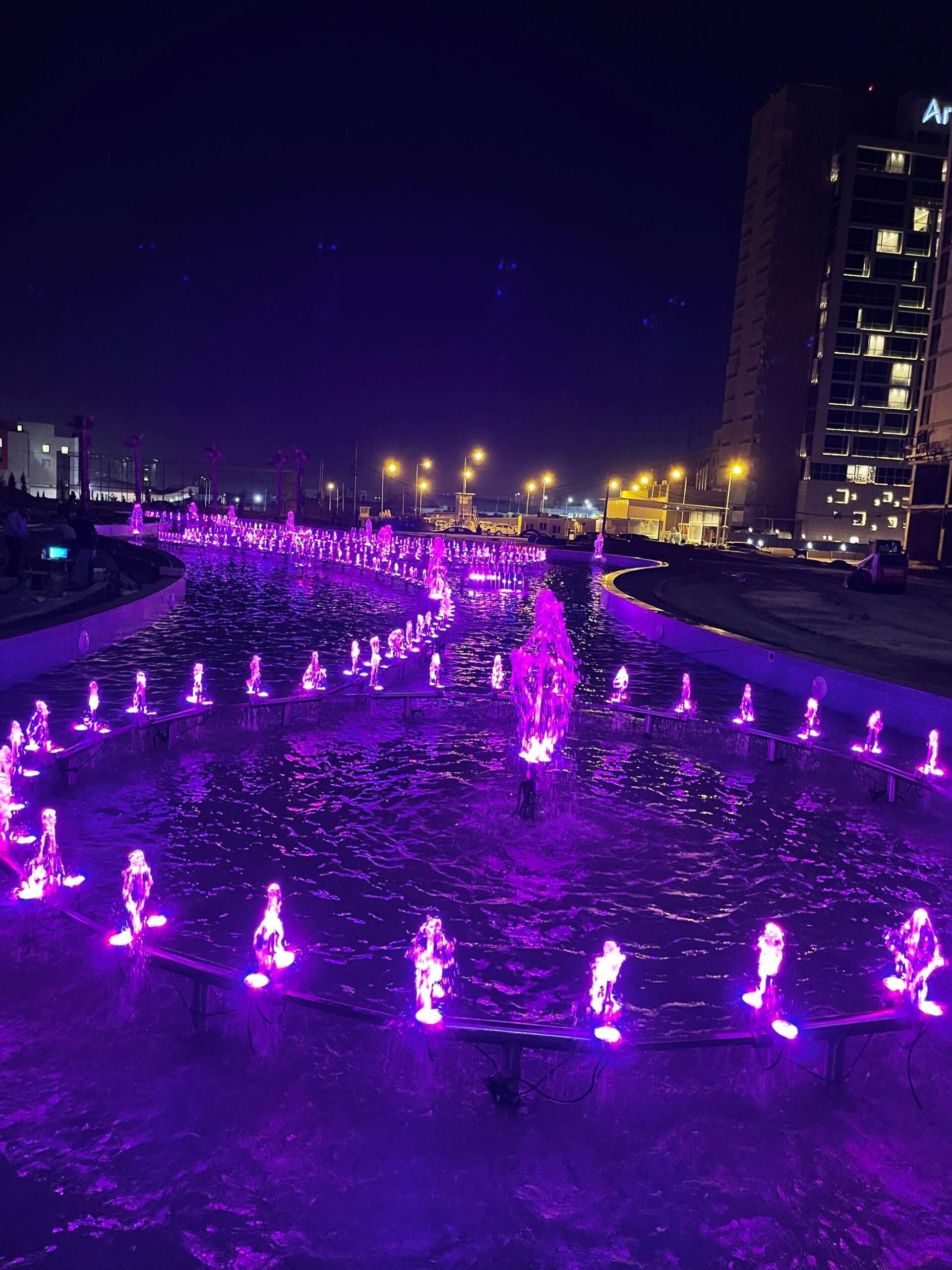 Gece aydınlatılmış dairesel fıskiye havuzu